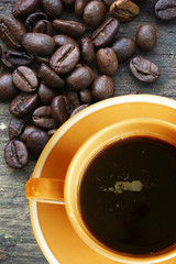 cup of coffee and coffee beans on old wooden table