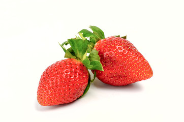 Fresh strawberries whole and cut  on a white background