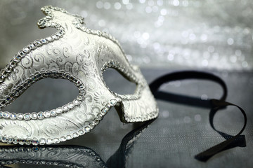 Vintage carnival mask in front of glittering background