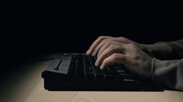 Hacker typing at pc keyboard caught