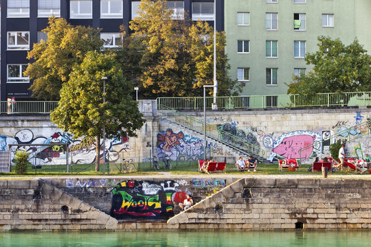 People have a break at the pier of the Danube Canal - Vienna