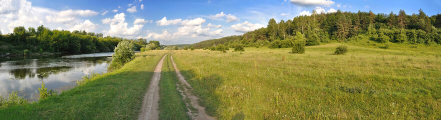 panoramic landscape of green field and clouds