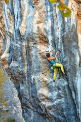 Rock climber climbing up a cliff