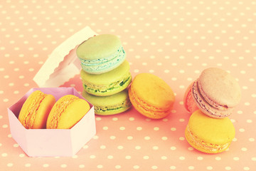 Tasty macaroons on pink polka dot background
