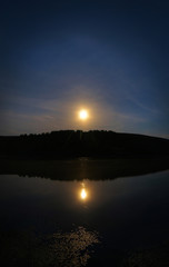 Obraz premium Midnight summer landscape with fool moon over a lake