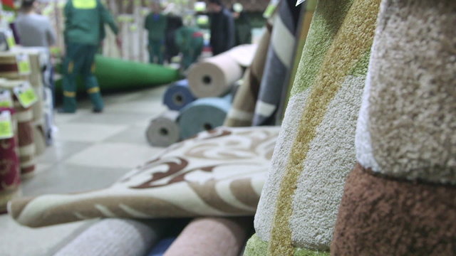Customers choosing and buying floor covering in carpet store