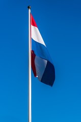Netherlands flag on the blue sky