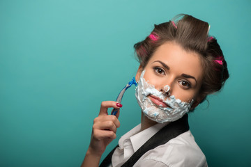Cute brunette woman in hair curlers posing with foam on face sha