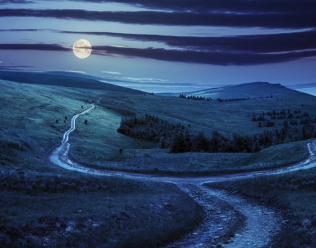 cross road on hillside meadow in mountain at sunrise at night