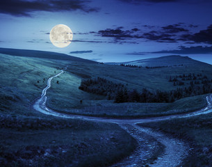 cross road on hillside meadow in mountain at sunrise at night