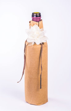 one bottle wrapped in paper with white flower