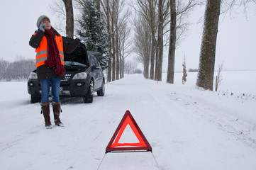 Junge Frau hat Autopanne im Winter