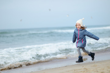 Adorable little girl playing by the ocean