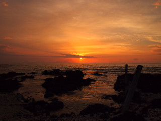 Naklejka premium Sunset over ocean with lava rocks of Holoholokai Beach in the fo