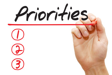 Hand writing Priorities List with red marker, business concept