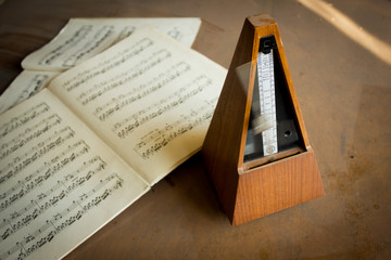 Fototapeta premium Wooden metronome sets the rhythm by swinging pendulum