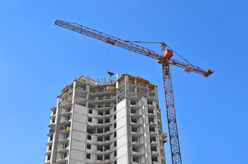 Crane and building construction site against blue sky