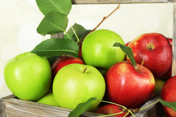 Ripe apples in crate on bright background