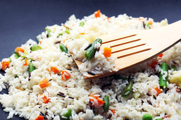 Tasty rice preparing in wok, close-up