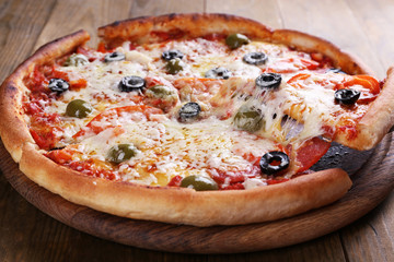 Pizza with cheese on board and wooden table background