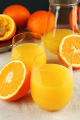 Glass of orange juice with slices on tablecloth background
