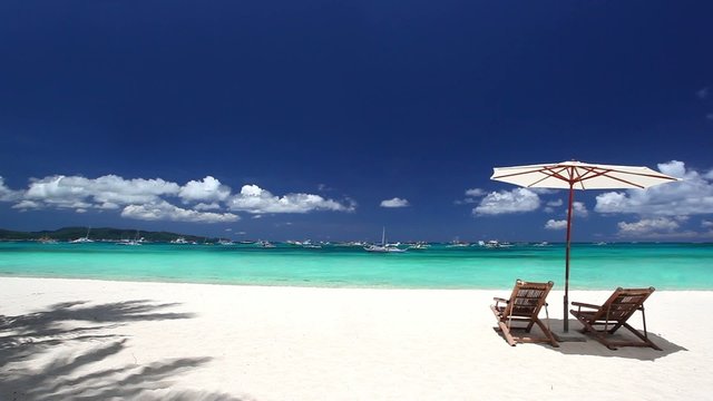 Tropical beach with sun umbrellas and beds
