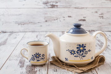 Tea Cup and Teapot, on White Wooden Background