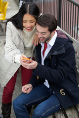 Happy couple reading text message on mobile phone
