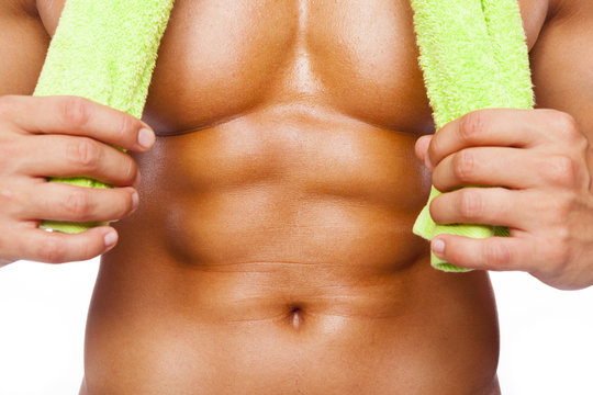 Fitness man holding a towel and showing six pack abs