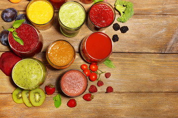 Glasses of tasty fresh juice, on wooden table.