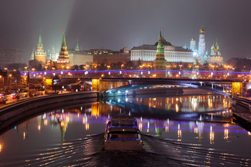 Obraz premium Moscow Kremlin at winter night. Moscow-river and boat.