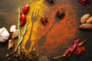 Spices on table with cutlery silhouette, close-up