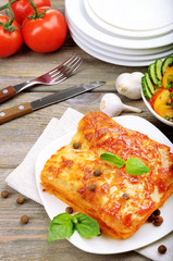 Portion of tasty lasagna on wooden table