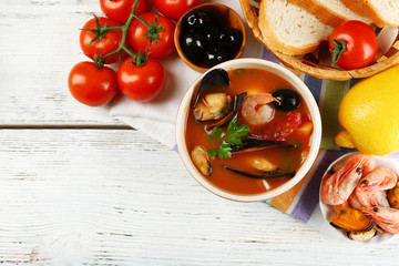Tasty soup with shrimps, mussels, tomatoes and black olives in