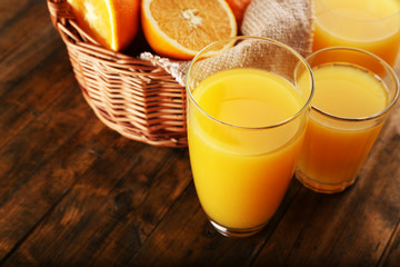 Glass of orange juice with slices and wicker basket with burlap