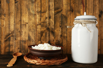 Milk can with bowl of cottage cheese and spoon