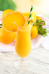 Glass of orange juice with straw and slices