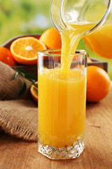Pouring orange juice from glass carafe,