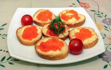 Canapes with red caviar on white plate