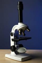 Microscope on table, on color background