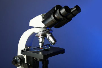 Microscope on table, on color background