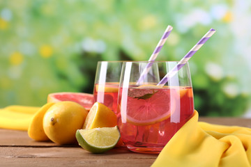 Pink lemonade in glasses on table on natural background