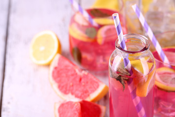 Pink lemonade in glasses and bottle on table close-up