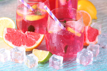 Pink lemonade in glasses and pitcher on bright background