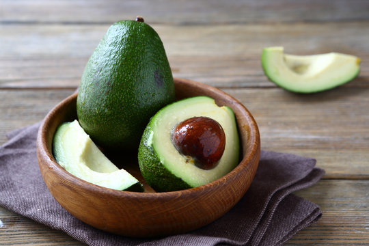 Fresh avocado in a wooden bowl