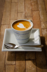 cup of cappucchino over wooden table