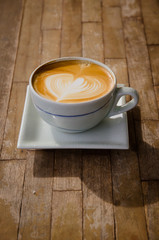 cup of cappucchino over wooden table