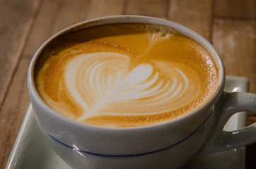 cup of cappucchino over wooden table