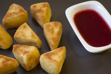 pieces of fried Camembert with currant sauce
