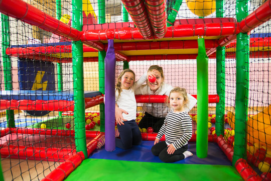 Mom and daughters in indoor playroom